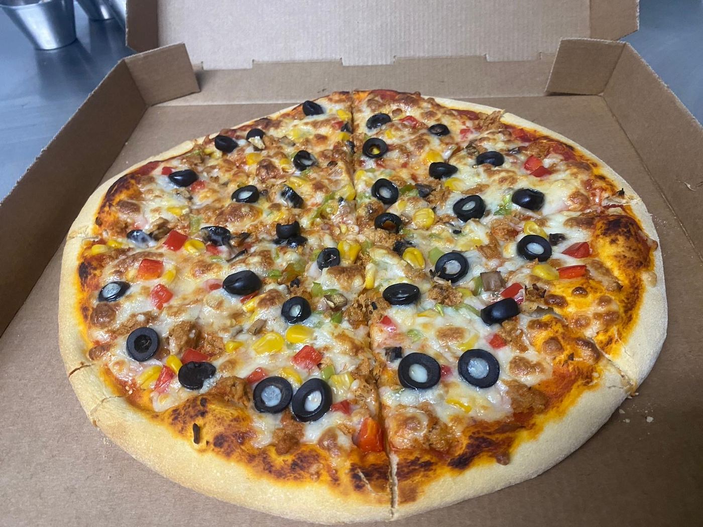 Pizza de pollo con aceitunas negras, una combinación clásica de la carta.