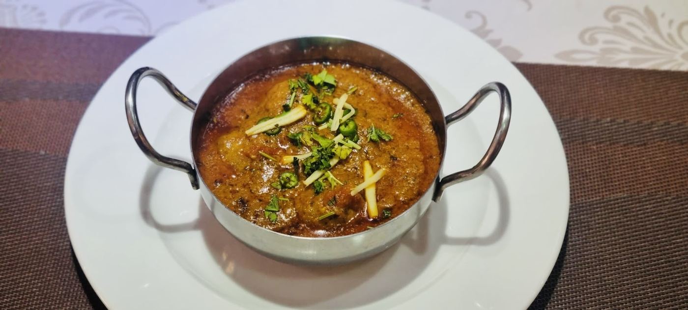 Curry de verduras con jengibre fresco, servido caliente en un cuenco tradicional.